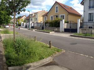 Aménagement de noues végétalisées et plantées d'arbres le long d'une rue bordée d'habitations