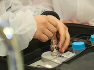 Aperçu des mains d'un/e élève en train de mélanger un échantillon d'eau