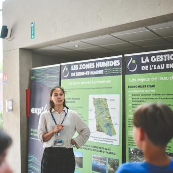 Une agent du Département présente l'exp'O 77 sur l'eau en Seine-et-Marne à des collégiens lors du Forum Départemental de l'EAU 2025