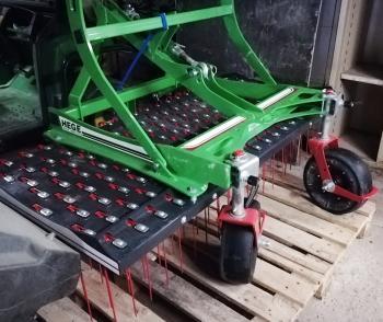 Un peigne à gazon, équipement muni de dents pour le désherbage des surfaces enherbées, à atteler derrière un tracteur