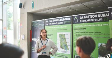 Une agent du Département présente l'exp'O 77 sur l'eau en Seine-et-Marne à des collégiens lors du Forum Départemental de l'EAU 2025