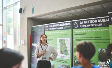 Une agent du Département présente l'exp'O 77 sur l'eau en Seine-et-Marne à des collégiens lors du Forum Départemental de l'EAU 2025