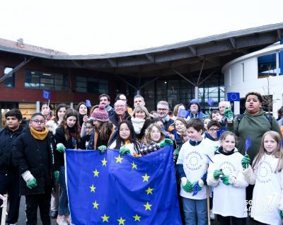 Des élèves du collège Blanche de Castille posent devant un drapeau Européen