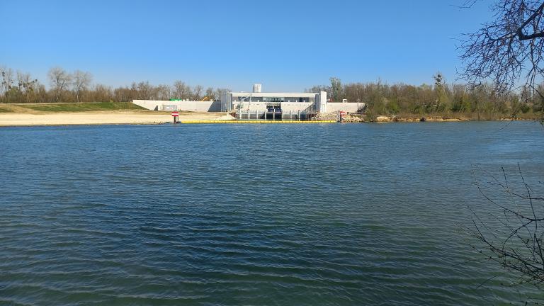 Vue ensoleillée sur une étendue d'eau, des bois sont tout autour dégarnis c'est l'hiver.